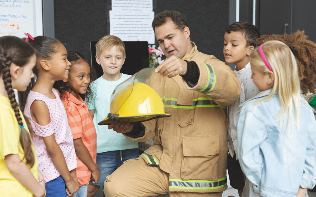 Firefighter showing how his helmet words to students in a classroom