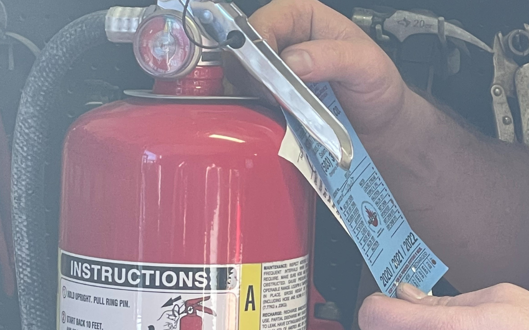 inspector checking safety tag on a fire extinguisher