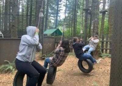 group of women swinging together on tire swings