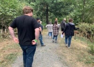 group of people walking in the woods looking at foliage